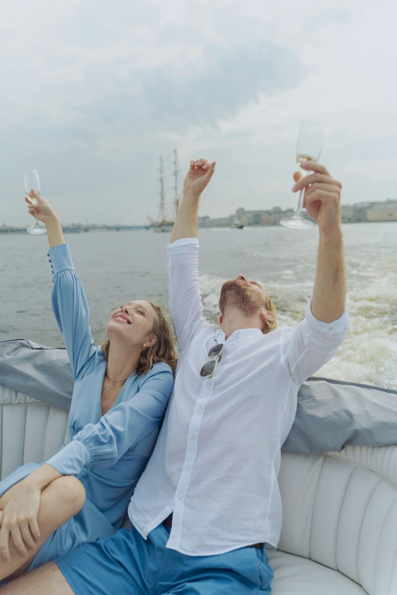 Happy couple toasting champagne glasses during a relaxing boat trip.